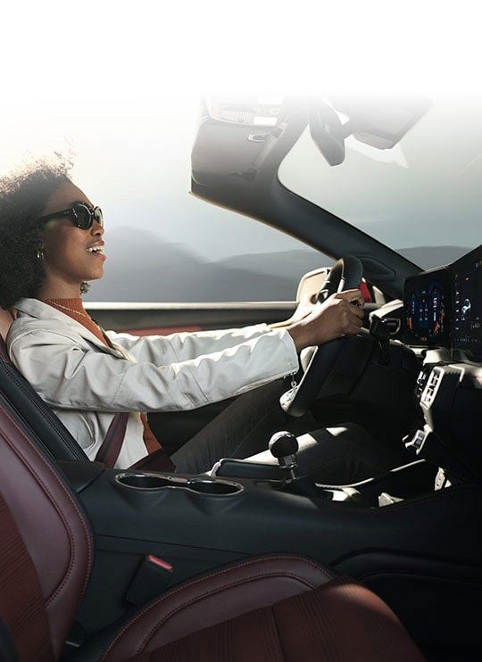 Person sitting in the driver’s seat of a 2024 Ford Mustang® convertible | Eau Claire Ford Lincoln in Eau Claire WI